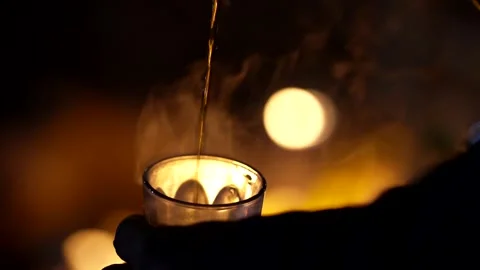 A typical Moroccan tea poured in front of the fire Stock Footage 276259335