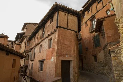 Typical orange-colored adobe and wood facades in the medieval village of Al.. Stock Photos