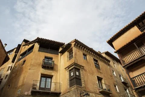 Typical orange-colored adobe and wood facades in the medieval village of Al.. Stock Photos