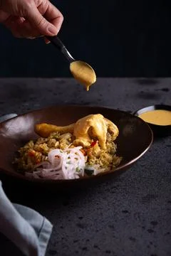 Typical Peruvian dish called arroz con pollo, presented on a dark background. Stock Photos