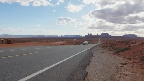 Typical road in Monument Valley National Park, with a passing car, Arizona, US Stock Footage 287725110