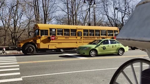 Typical school bus passing on a modern street in rush hour Stock Footage 136203575