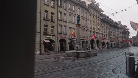 Typical street during the day in Bern Old town with old fountain and flags Stock Footage 337601387