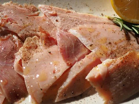 Typical tapas from Spain. Pork ham slices with lemon juice, rosemary and red Stock-Fotos