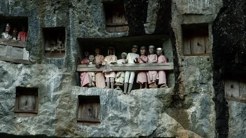 Typical Toraja tombs in a vertical rock face carved with traditional puppets Stock Footage 102592951