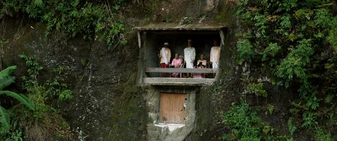 Typical Toraja tombs in a vertical rock face carved with traditional puppets Video stock 102593411
