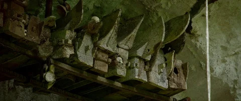 Typical Toraja tombs in a vertical rock face carved with traditional puppets Stock Footage 102597908