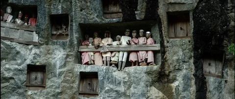 Typical Toraja tombs in a vertical rock face carved with traditional puppets Stock Footage 102603621