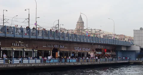 Typical yet charming view of Galata Bridge, restaurants and people fishing Stock Footage 318683123
