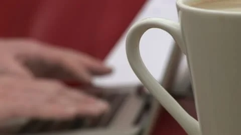 Typing and drinking cup of coffee Видео 21582331