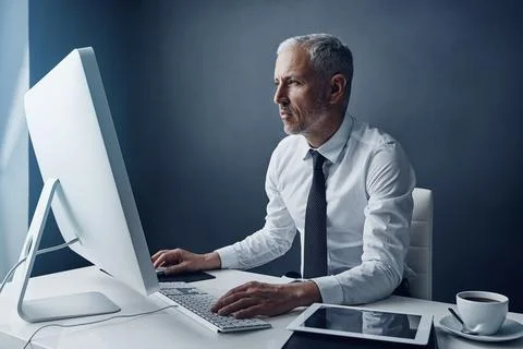 Typing auditor, computer and elderly man in studio, working and isolated on a Foto stock