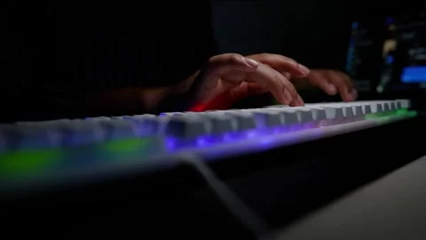 Typing on Backlit Keyboard in Dark Room, Hands typing on a backlit keyboard.. Stock Footage 317737388
