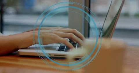 Typing bare-forearmed hands on silver laptop at wooden table by window, HUD Stock Photos