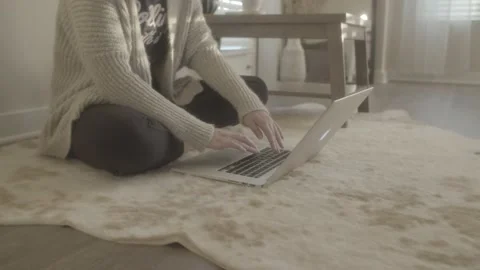 Typing on computer on floor Stockbeeldmateriaal 143867014