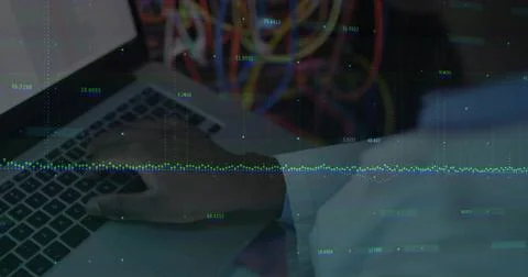 Typing engineer's right hand on silver laptop keyboard in server room, with data Foto stock