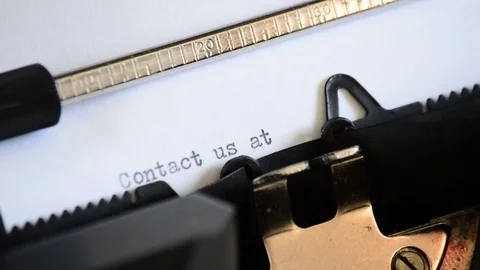 Typing the expression Contact us at with an old manual typewriter Stock Footage 72662245