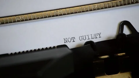 Typing the expression NOT GUILTY with an old manual typewriter Stock Footage 73249970
