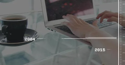 Typing hands over laptop keyboard at cafe on glass table, with coffee cup and Stock Photos