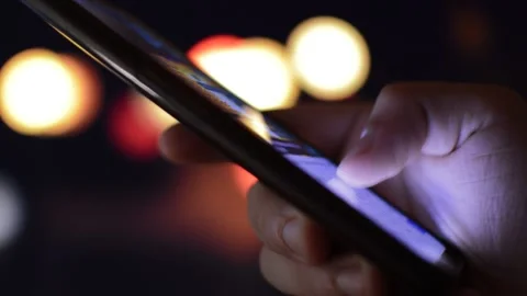 Typing on iphone in a night city background. man's hand typing in iphone Video stock 202321846
