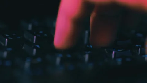 Typing on keyboard macro footage with dark night lights and colours	 Stock Footage 253434966