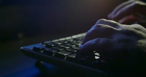 Typing on keyboard at night. Dark background lighting. Close-up Stock Footage 97883795