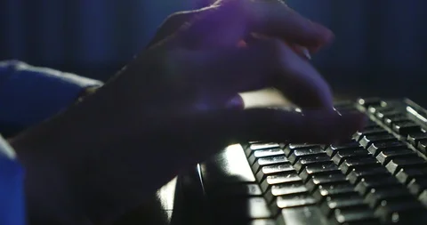 Typing on keyboard at night. Dark background lighting. Close-up Stock Footage 99010924