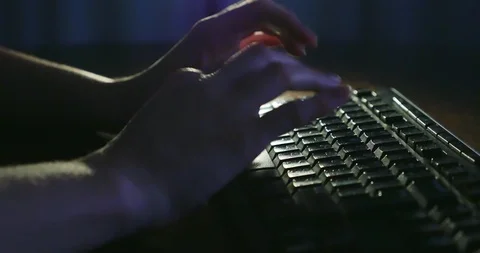 Typing on keyboard at night. Dark background lighting. Close-up Stock Footage 99053926