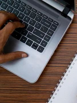 Typing on a keyboard while working on a project. A lap top, a mobile, calcula Stock Photos