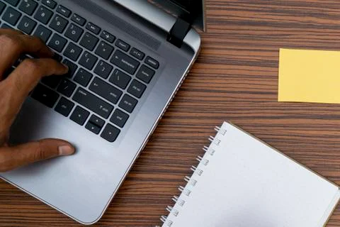 Typing on a keyboard while working on a project. A lap top, a mobile, calcula Stock Photos
