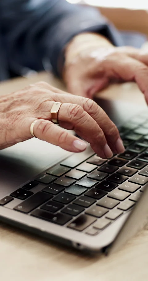 Typing, laptop and senior hands at table, technology competence and keyboard Stock Footage 330924691