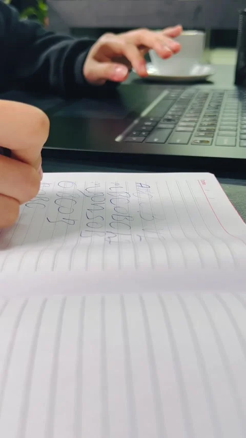 Typing on a laptop and taking notes in a notebook Vídeos de archivo 336136108