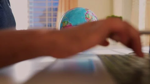Typing on Laptop with Globe in Background Stock Footage 320725598