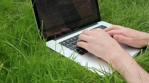Typing on laptop in grass Video stock 11868108