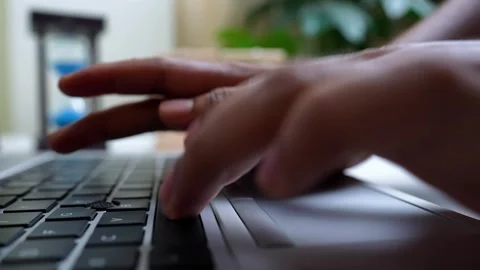 Typing on Laptop with Hourglass in Background Stock Footage 320724269