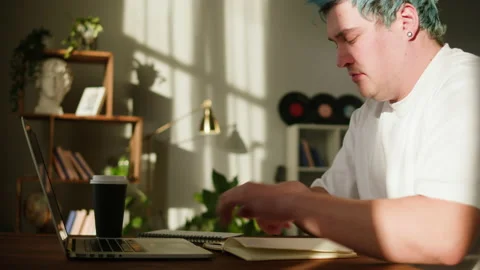 Typing on laptop keyboard close-up. Man with blue hair working in office Vídeo Stock 180551908