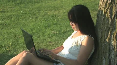 Typing on a laptop in the park Stock Footage 11516805