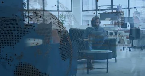 Typing man on blue sofa in office lounge, wearing sweater, using laptop, dotted Stock Photos