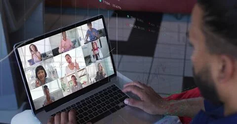 Typing man in casual shirt using laptop showing 3x3 grid, stock charts at home, Stock Photos