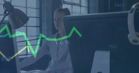 Typing office worker wearing light blouse at desk with large monitors, green Stock Photos