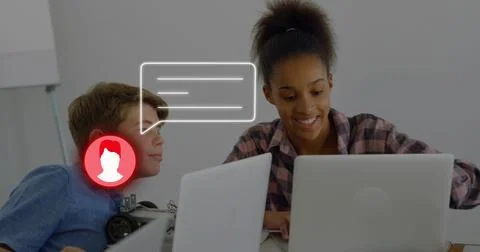 Typing plaid student guiding robot on classroom table with laptops, flipchart, Stock Photos