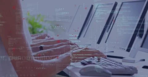 Typing programmer hands pressing keys on keyboards at office row, with monitors, Stockfoto's