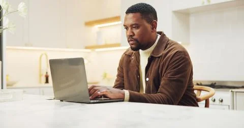 Typing, remote work and black man with laptop in kitchen, ebook manuscript .. Stock Photos