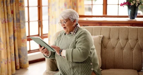 Typing, tablet and relax with old woman on sofa for bingo app, online game or Stock Footage 312311545
