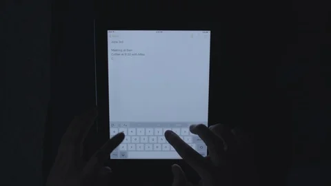 Typing on a tablet in the dark from a top down perspective. Stock Footage 85527868