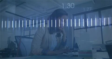 Typing woman in light blazer patterned-cuff leaning on hand at open-plan desk, Stockfoto's