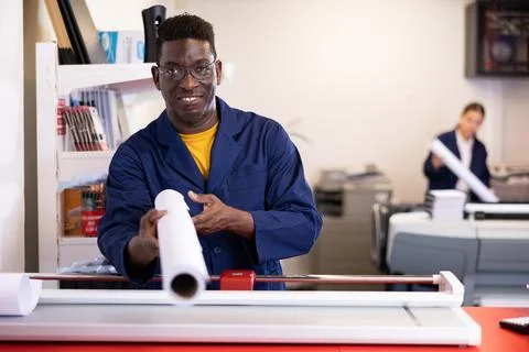 Typography technician offering plotter paper roll Fotos de archivo