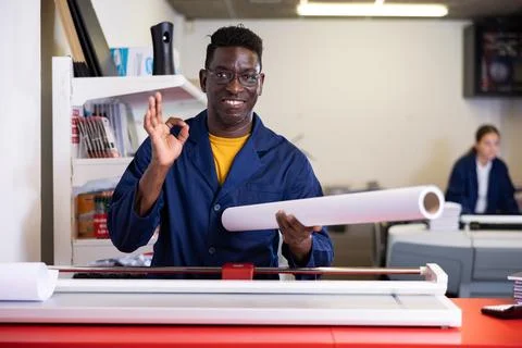 Typography technician offering plotter paper roll Foto stock