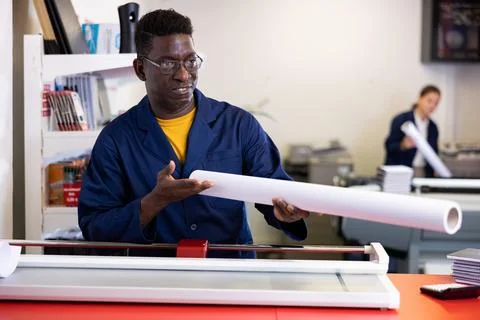Typography technician offering plotter paper roll Stock Photos