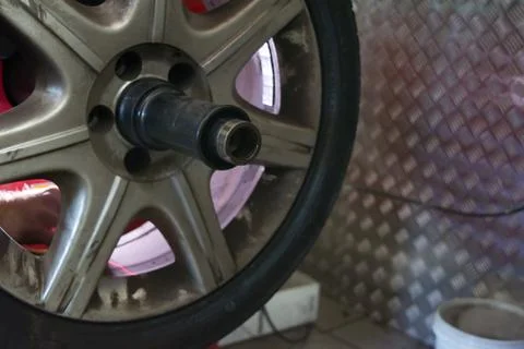 Tyre on the balancing machine prepared for balancing at the tyre shop Stock Photos
