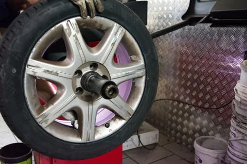 Tyre on the balancing machine prepared for balancing at the tyre shop Stock Photos